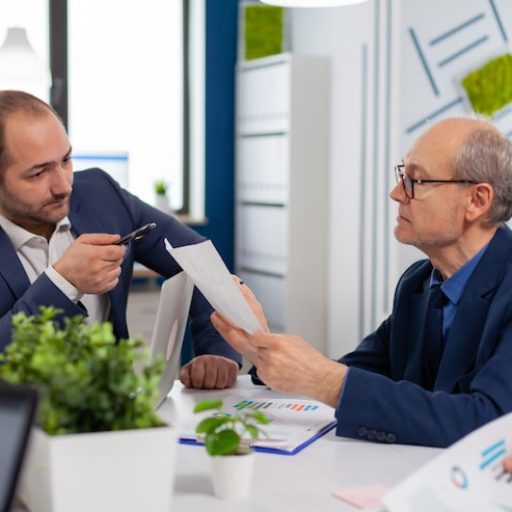 senior-entrepreneur-discussing-with-coworker-holding-documents-conference-briefing-businessman-discussing-ideas-with-colleagues-about-financial-strategy-new-start-up-company_482257-5074
